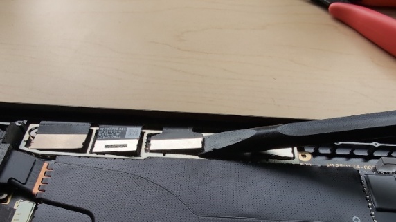 Screenshot that shows a technician using a nylon spudger to gently disconnect flat ribbon connectors from a display assembly.