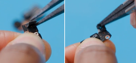 Photo that shows holding the device while disconnecting a small flex cable.