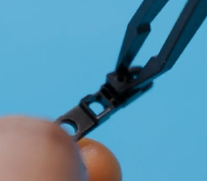 Photo that shows tweezers positioning the microphone rubber into the deck.