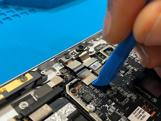 Photo that shows disconnecting the IR camera FPC connector using a plastic opening tool.